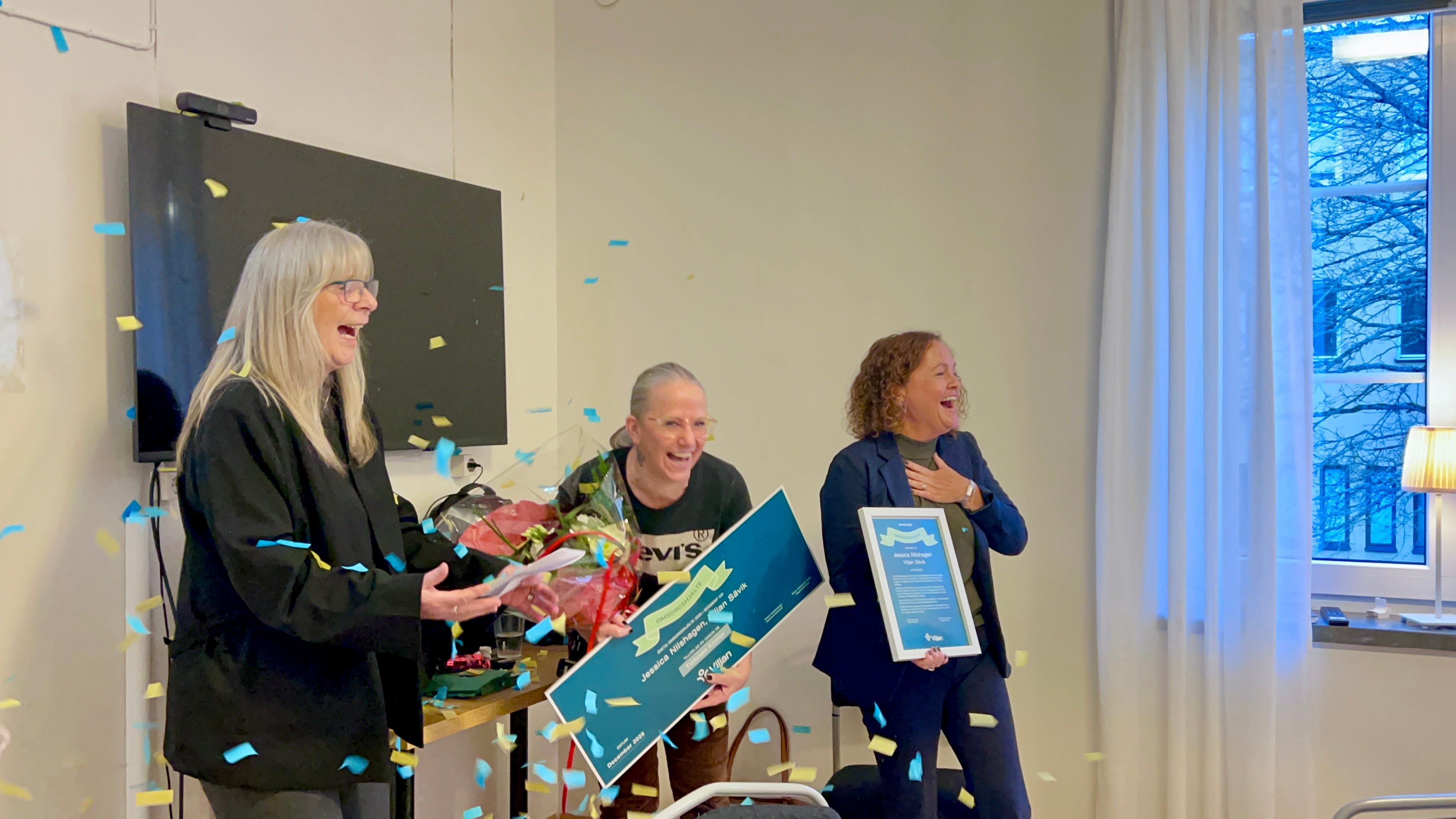 Konfetti strösslas över vinnaren och hon och cheferna skrattar