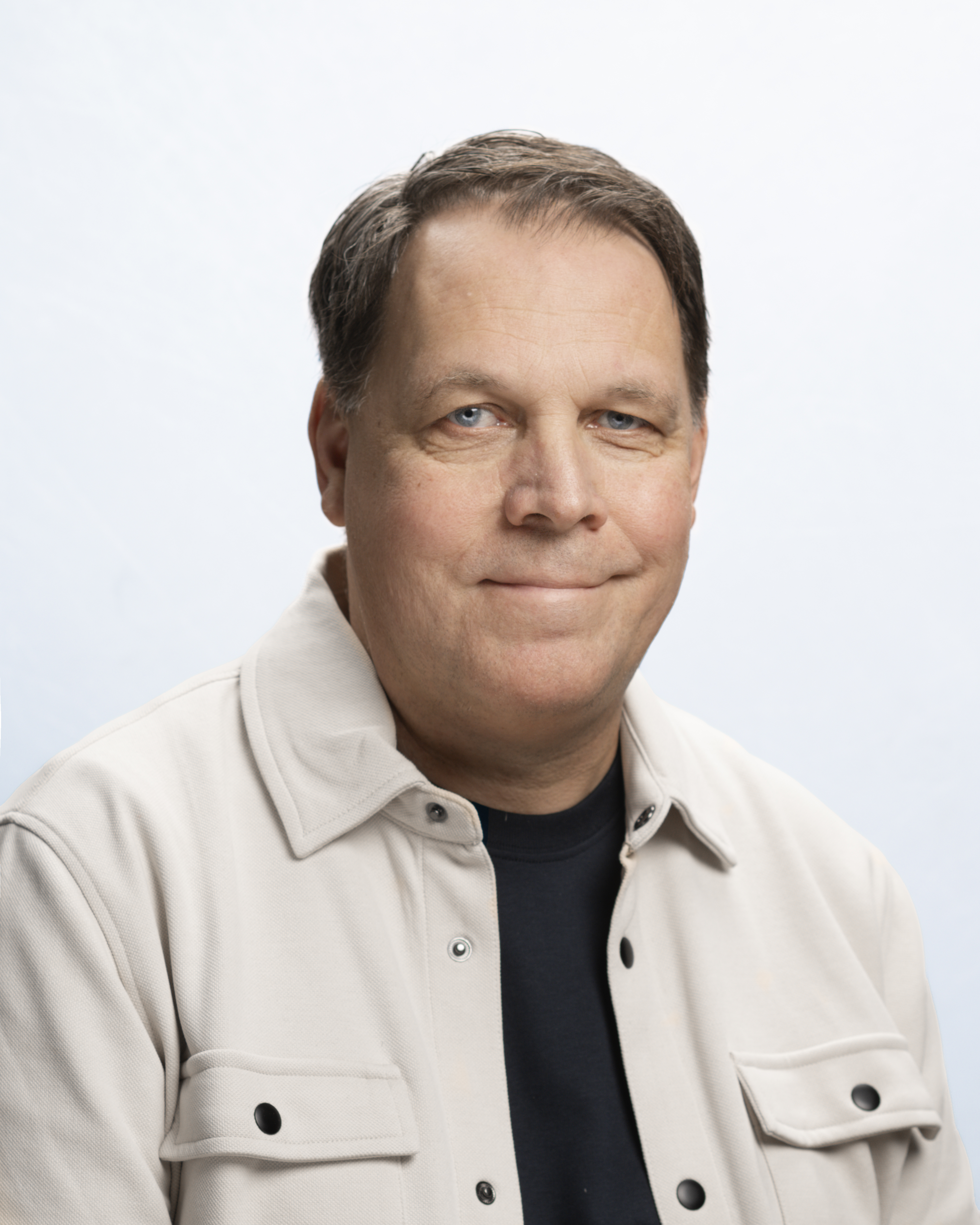 Man i grå tröja med ljus bakgrund