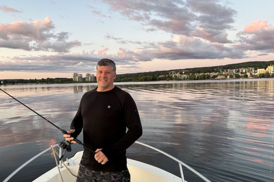 Behandlingsansvarig Ronnie på en båt med fiskespö i handen