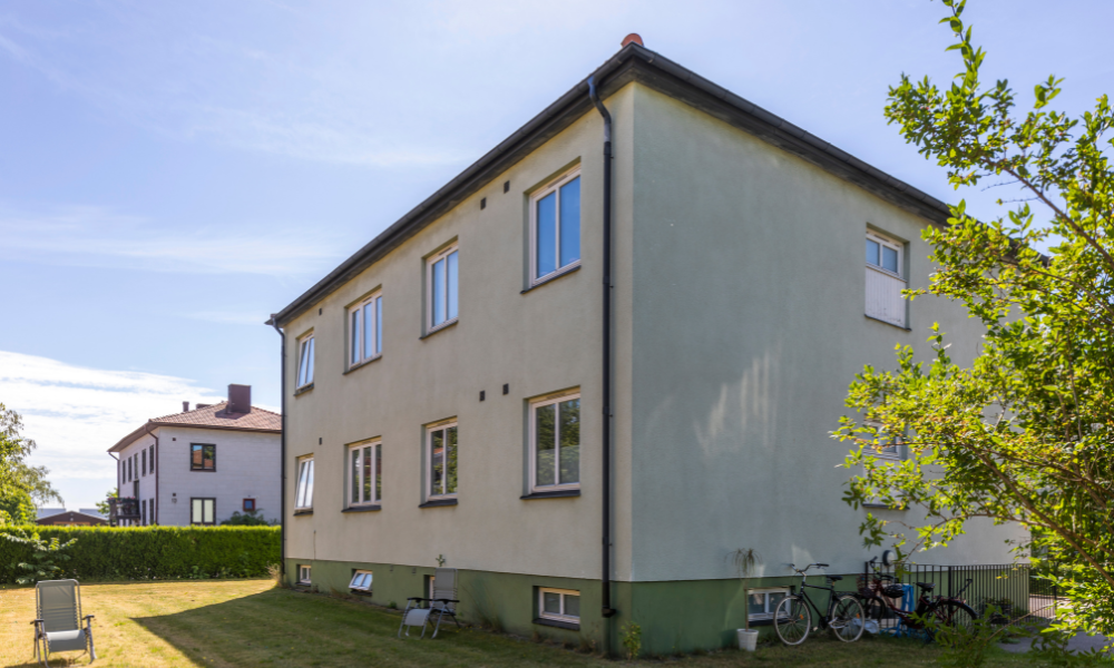 Tvåvåningshus i ett lugnt bostadsområde med grönska och cyklar parkerade utanför