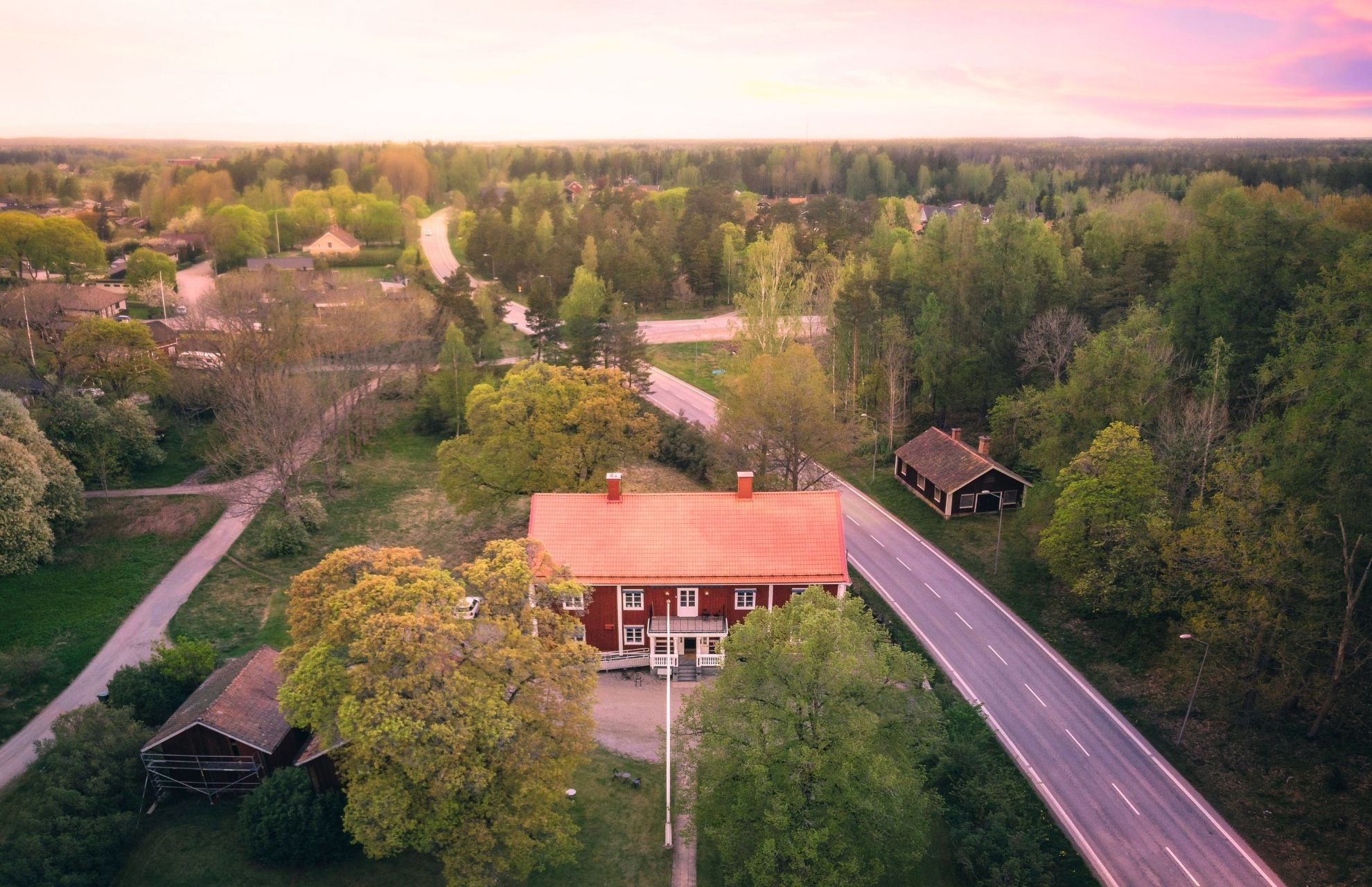 Viljan Friskola, som är ett rött trähus, ovanifrån, omgett av träd och otrafikerade vägar