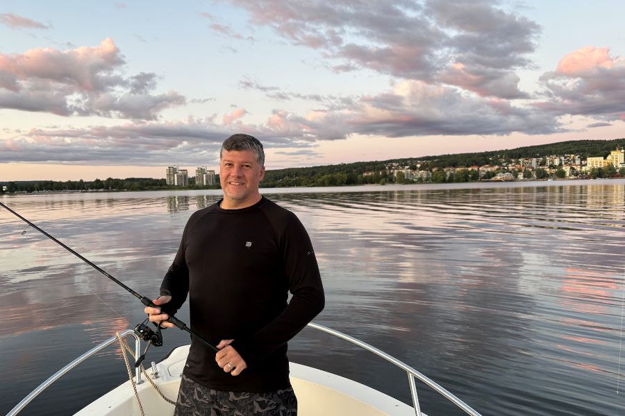 Behandlingsansvarig Ronnie på en båt med fiskespö i handen